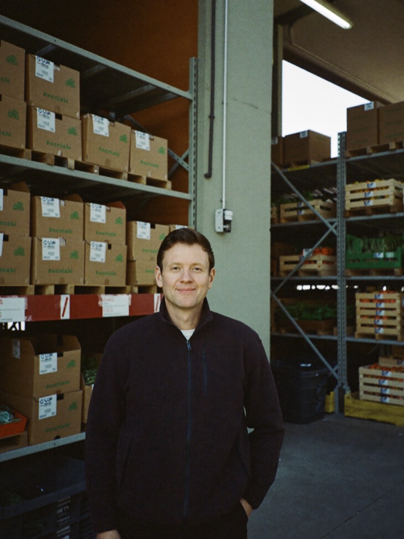 Food distribution owner between warehouse shelves